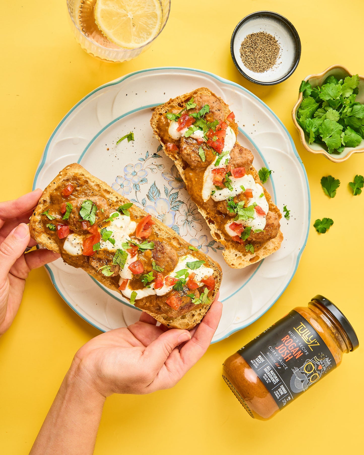 Rogan Josh Mumbai Meatball Subs filled with saucy meatballs, lettuce, and onions, garnished with coriander.