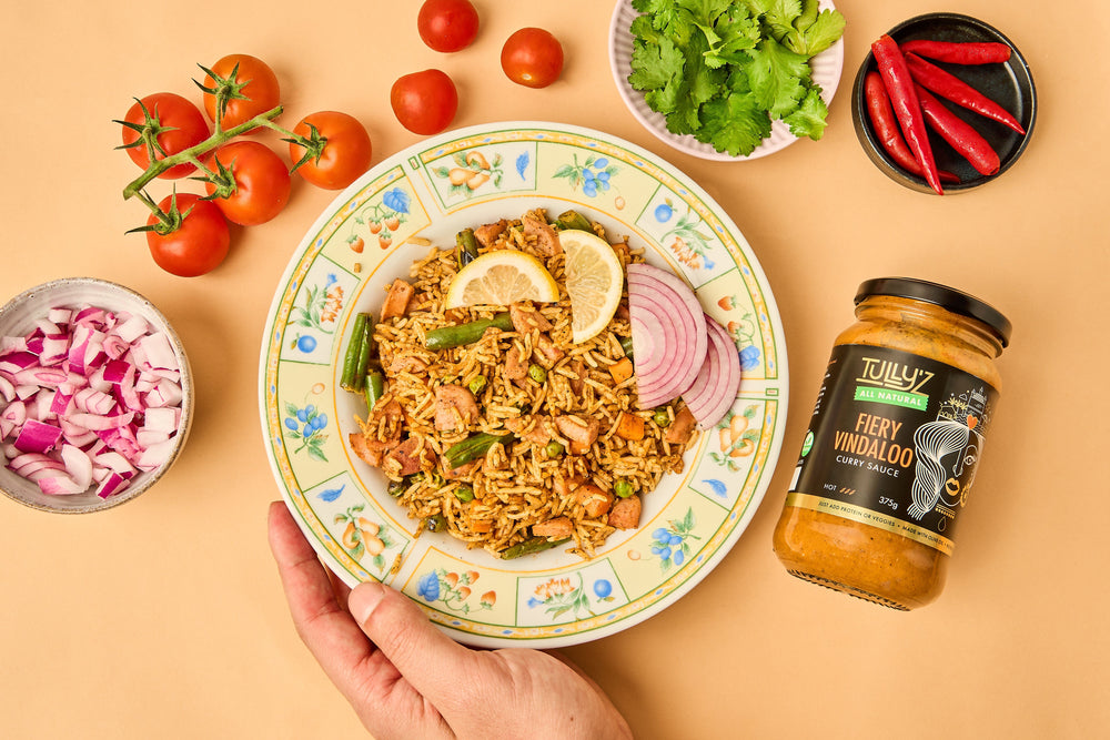 A bowl of Biryani (Spiced Rice) garnished with fresh coriander and cashews.