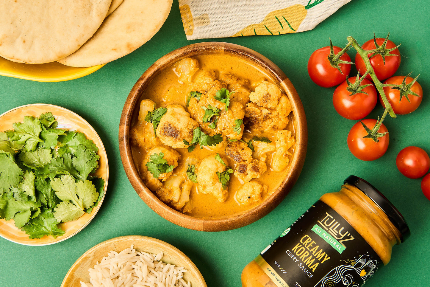 Whole roasted cauliflower coated in creamy korma sauce, garnished with fresh coriander