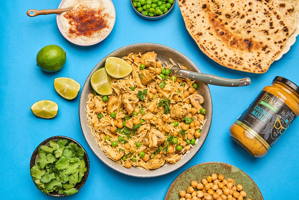 A bowl of Coconut Masala Chicken Biryani garnished with fresh coriander and cashews.