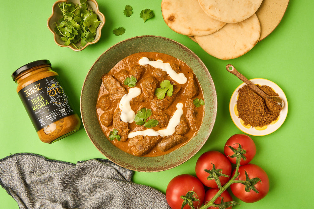 A bowl of Tikka Masala Sausage Curry garnished with fresh coriander.