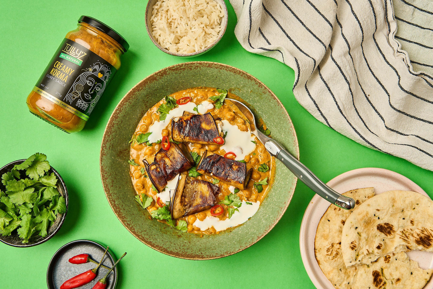 A bowl of Creamy Korma Eggplant and Chickpea Curry, garnished with fresh coriander.