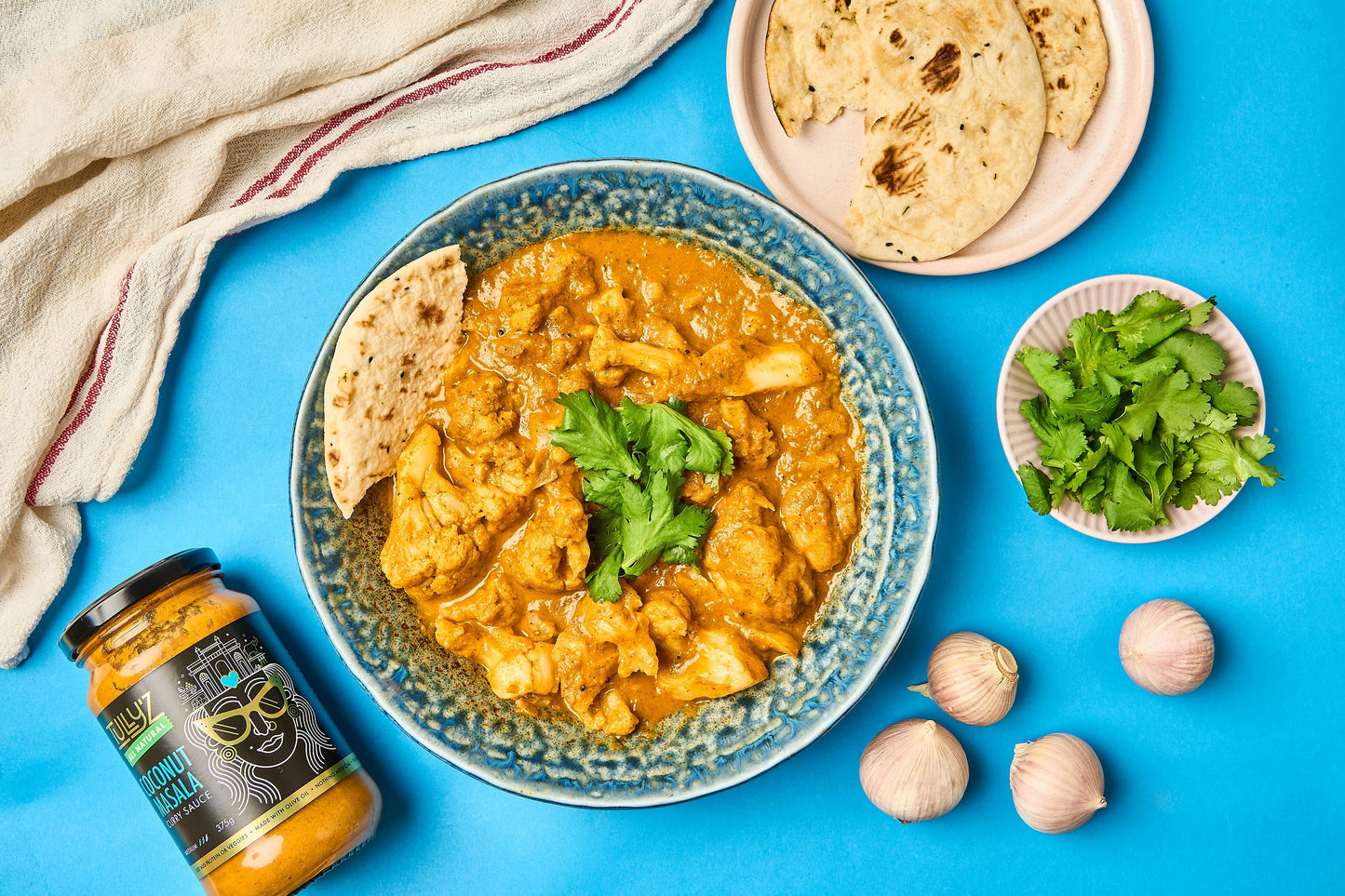 A bowl of Coconut Masala Cauliflower Chicken Curry served with fresh coriander garnish