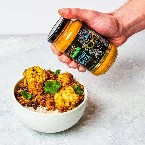 Coconut Masala Cauliflower Curry served with rice, garnished with fresh coriander and tomato